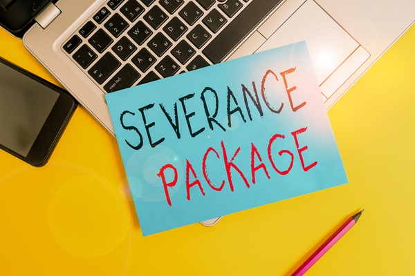 Blue card with the words “Severance Package” in bold black and red letters placed on a laptop keyboard, with a smartphone, pencil, and bright yellow background.